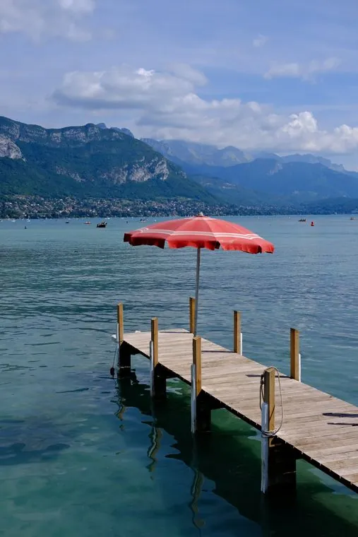 Guarda-sol vermelho em um píer do lago de Annecy